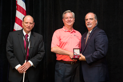 Chairperson J. Anthony Poleo (right) and Vice Chairperson James A. Kesteloot (left) with recipient Michael Gilliam (center).