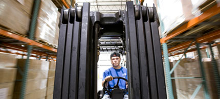 Photo of man driving forklift.
